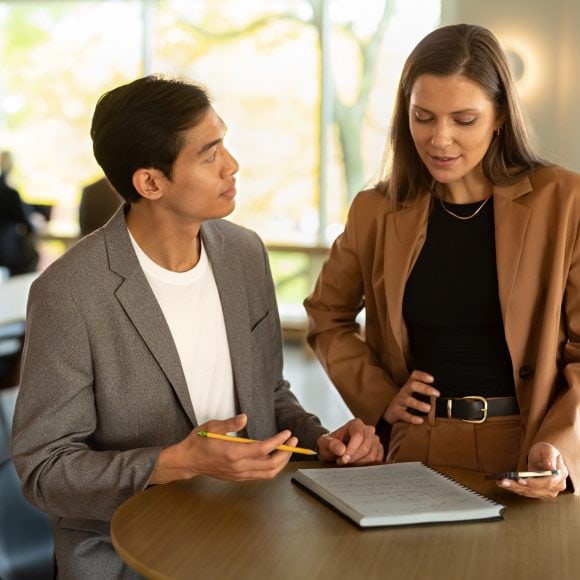 Two people in the office talking with each other
