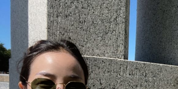 wo people standing in front of a sign that says "Washington" Theyre both wearing sunglasses and holding a thumbs up.