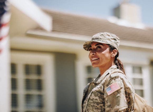 woman in uniform with a house in the background