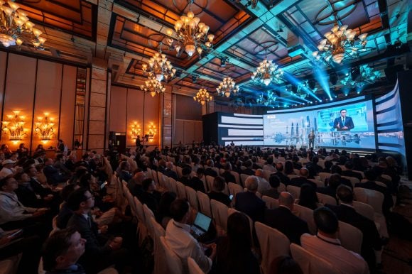 Large conference image from AIC 2025 with speaker onducting a welcome talk