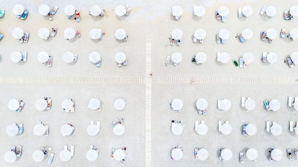 Aerial view of beach lined with thatch parasols, Rhodes island, Greece.
