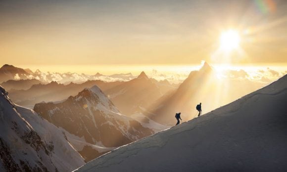 3 people climbing a mountain