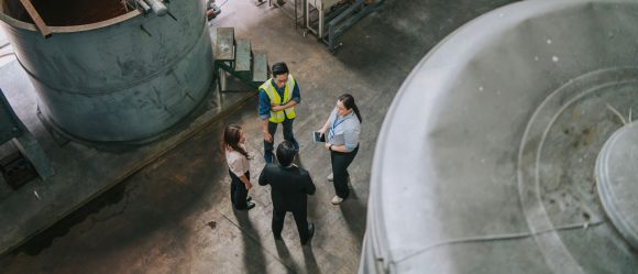 Four business people discussing logistics in a warehouse