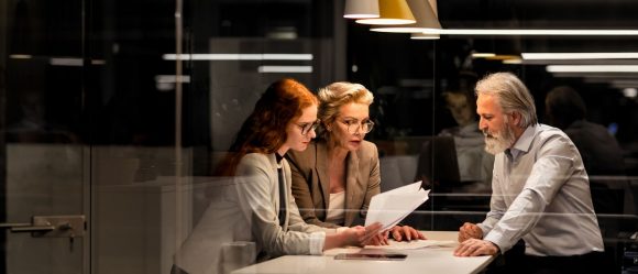 Three people having business meeting talking about investing in office