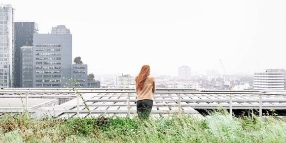 woman standing on a terrace looking over a city