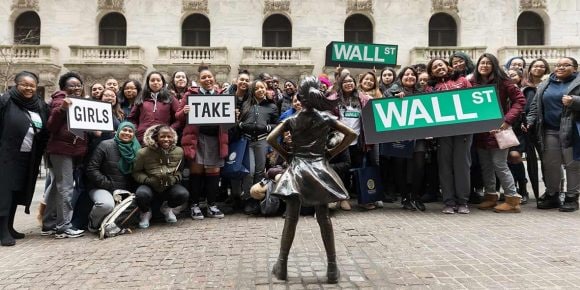 A group of girls with signs: Girls take Wall Street