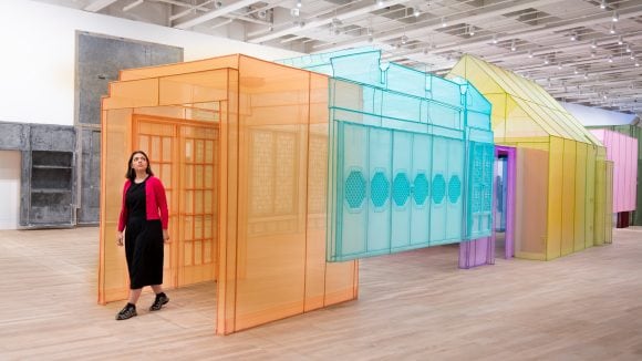 Woman walking through colorful mesh art installation