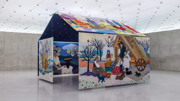 Colorful house-shaped art with folk scenes