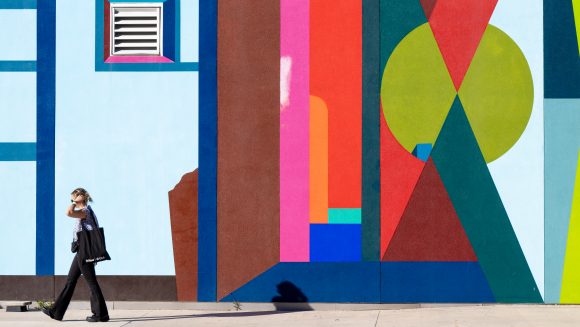 Woman walking past mural