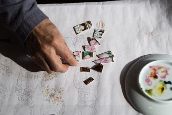Person arranging some art pieces into a structure