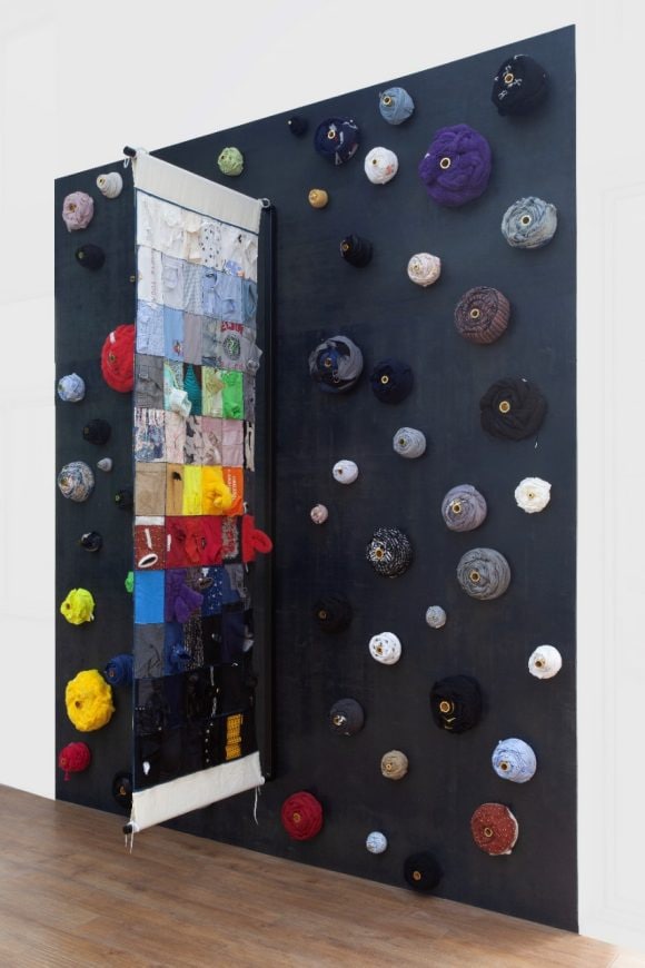 ‘Flag Gate UBS,’ 2024-25 Worn cloths collected from different people of UBS, fabric, wooden boards, copper tubes, mirror