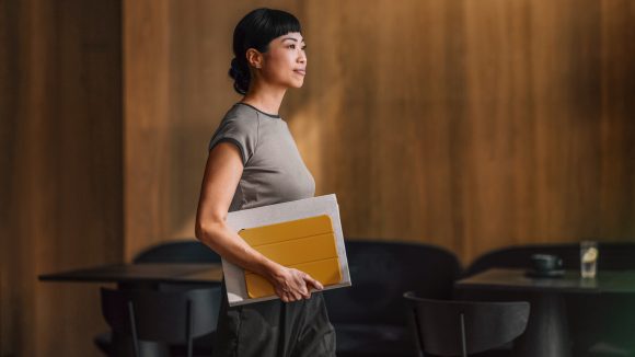 Confident businesswoman with notebook in office