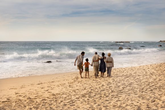 Three generation family walking on beach