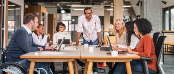 Four employees collaborating together at a table 