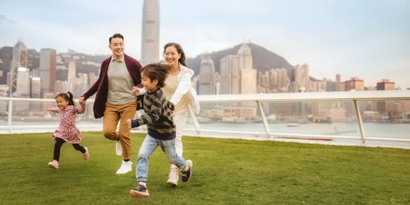 Family running in front of Hong Kong skyline