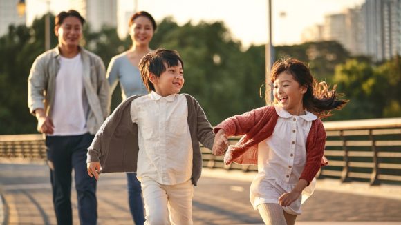 Family running in front of Hong Kong skyline