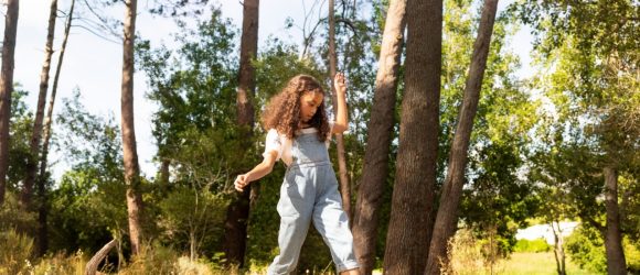 Girl balancing on tree trunk in park