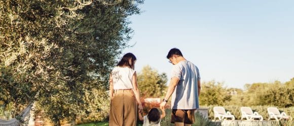 Parents holding hands with daughter