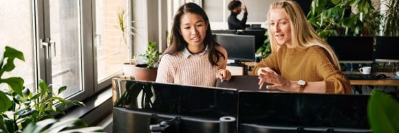 Two colleagues discussing in front of computer