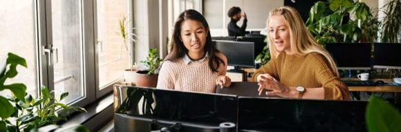 Two colleagues discussing in front of computer