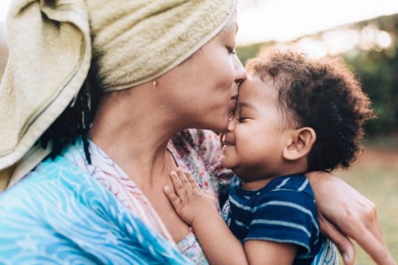 A mother kissing a young child