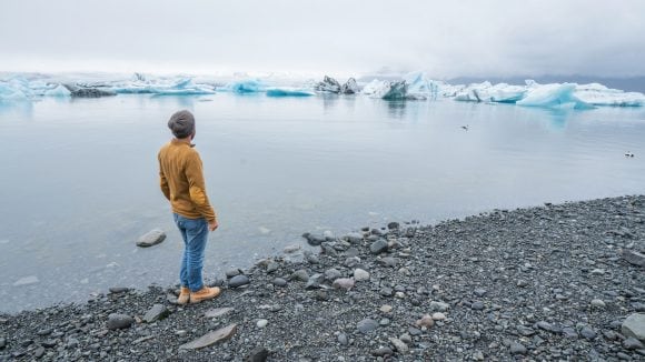 A man looking over a glacier lake