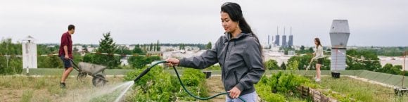 A young asian woman watering the plants in the garden