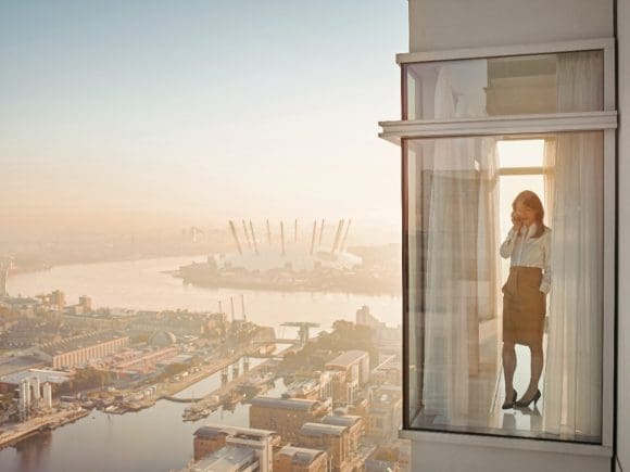 A women speakig on phone while standing in office balcony