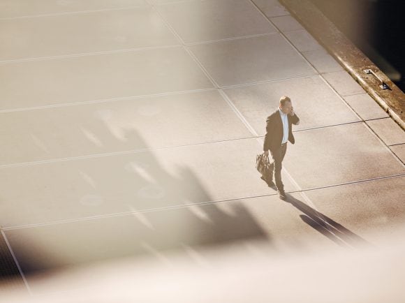 A man walking on street while talking on phone