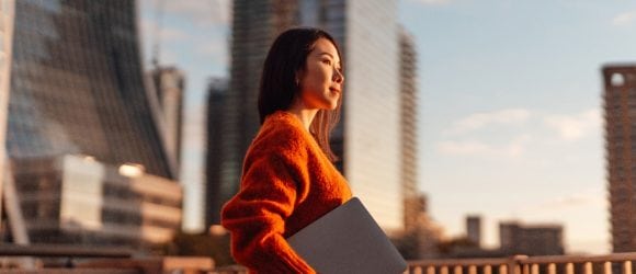 Businesswoman with laptop against London financial district