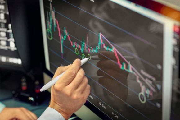 Stockbroker analyzing chart on computer monitor