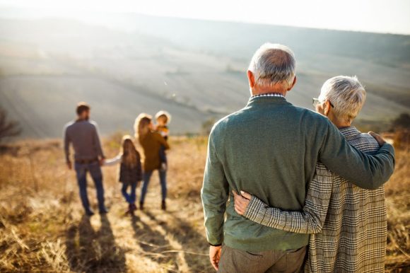Pareja mayor caminando en el campo con familia