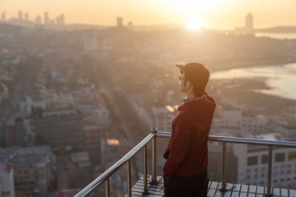 Persona contemplando la ciudad desde una terraza