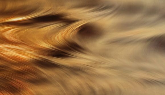 Patrón abstracto dorado con movimiento fluido