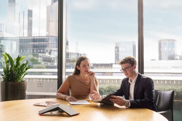 Dos colegas de trabajo sentados en una reunión