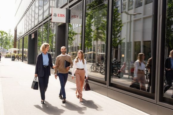 Tres colegas de trabajo caminando juntos afuera de la oficina