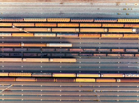 Vista aérea de trenes de carga alineados en múltiples vías ferroviarias.