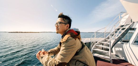 Hombre observa el mar desde la cubierta de una embarcación.