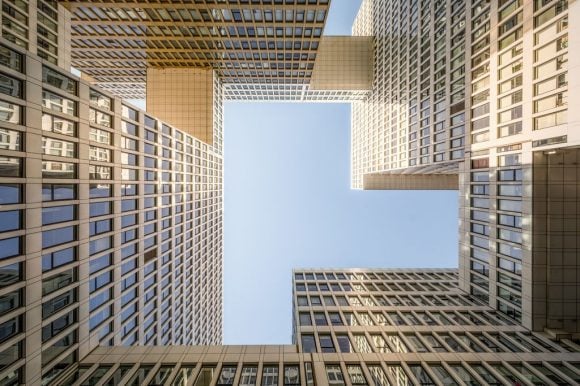 Vista hacia arriba de edificios modernos formando un marco alrededor del cielo.