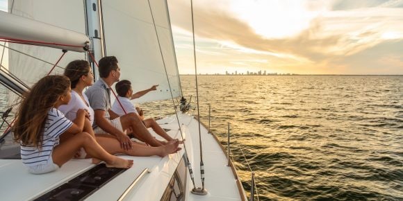 Familia navegando en un barco, con niños y adultos disfrutando juntos del paseo.