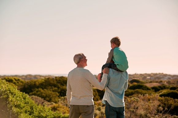 Adultos y niño en un entorno natural al atardecer.