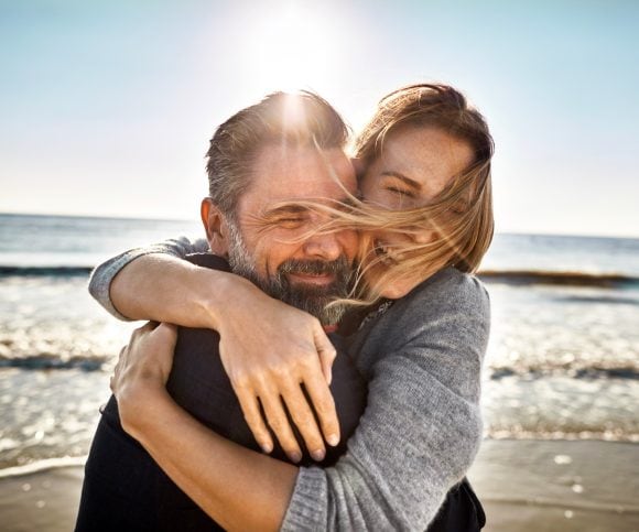 Hombre y mujer abrazándose en la playa