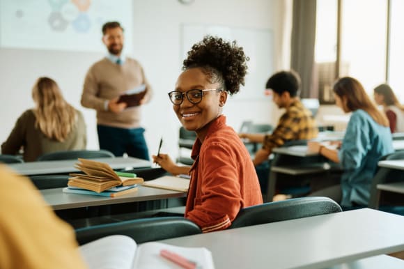 Jeune femme souriant à la caméra à l’école