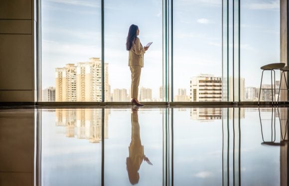 Businesswomen with tablet computer looking out of window