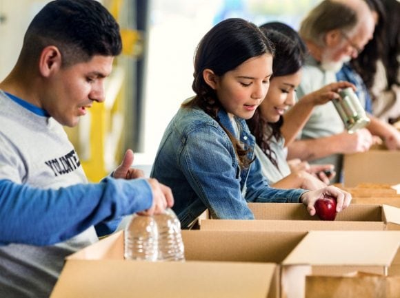 Volunteers sorting food donations into boxes