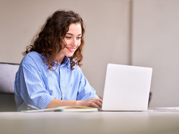 Giovane donna che lavora al computer portatile
