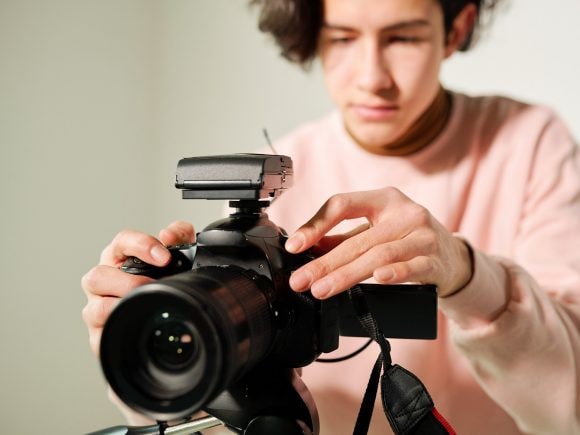 Giovane uomo che prepara una videocamera