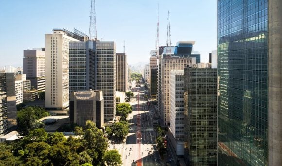 Avenida larga cercada por edifícios comerciais altos