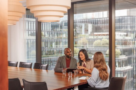 Três pessoas em uma reunião de trabalho