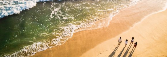 Família caminhando na praia